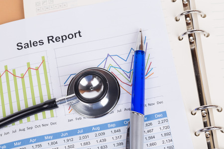 sheet of annual sales report with stethoscopeの写真素材