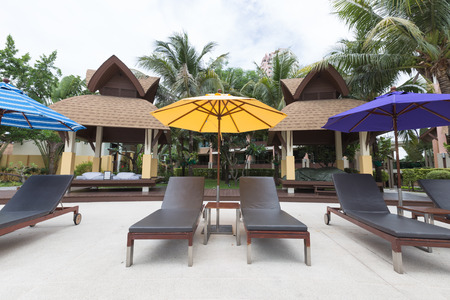 Beach sofa with umbrella beside swimming poolのeditorial素材