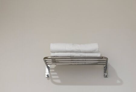 Clean towel on rack in hotel bathroomの写真素材