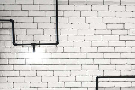 interior design of vintage wall. brick wall with light bulbs and pipes, low lit bar interiorの写真素材