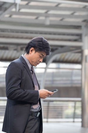 Businessman is under pressure reading on his mobile phone during a day time in a cityの写真素材