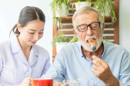Nurse assist senior man having breakfast togetherの写真素材