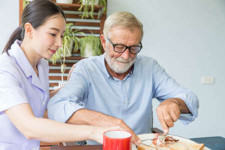 Nurse assist senior man having breakfast together