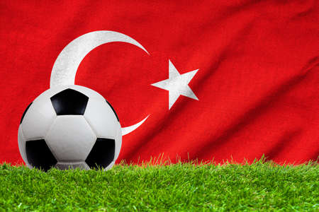 Football on grass field with wave flag of Turkeyの写真素材