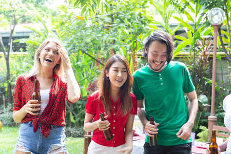 Group of friends having fun and happy in barbecue party at house backyardの写真素材
