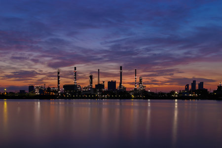 Oil refinery in front of a river during twilight in the evening