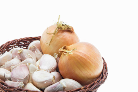 Garlic and onion in wicker basket isolated on white backgroundの写真素材