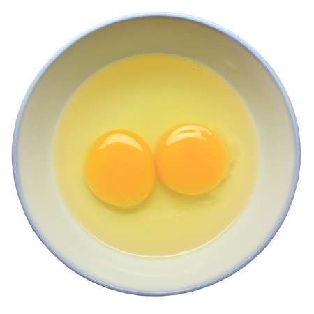 Twin yolks in cup on white backgroundの写真素材