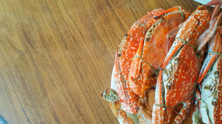 Baked crab place in a white plate on the wooden tableの写真素材