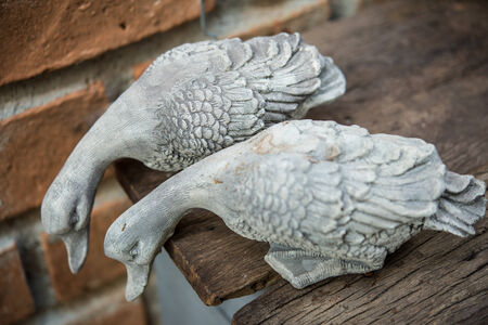 Duck sculpture on wooden floors and old brick walls.の写真素材