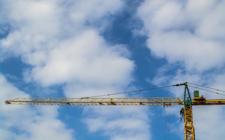 A construction crane with cloudy blue skyの写真素材
