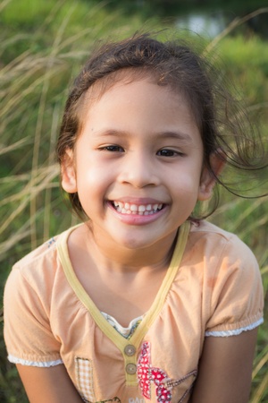 A smiling cute girl on the field under sunlightの写真素材