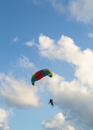 people playing a parachute with cloudy blue skyの写真素材