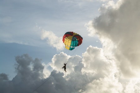 people playing a parachute with cloudy blue skyの写真素材