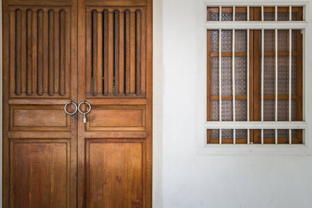 Chino Portuguese style architecture, wooden door and wooden window on concrete wallの写真素材