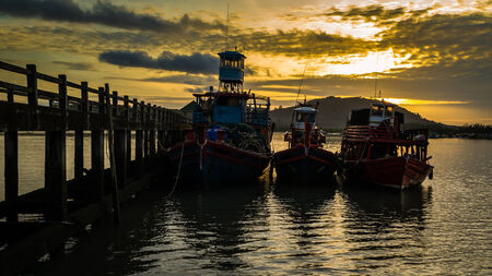 fishing boats at the pier during sunset
