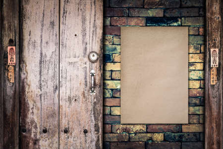 Old paper on the brick wall with retro wooden doorの写真素材
