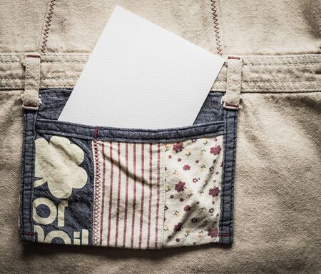 Close up white card in a pocket of a cloth