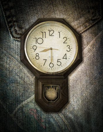Old vintage clock on texture of jeans backgroundの写真素材
