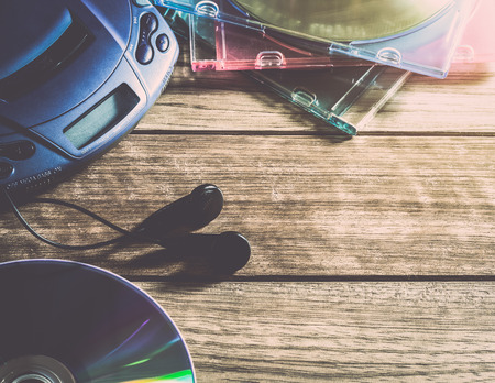 CD player with disc and earphones on wooden plank under warm lightの写真素材