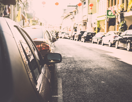 Many cars parking on the road under sunlight in old town of phuket, Thailandの写真素材