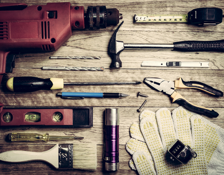 Set of tools over a wooden plank in vintage background