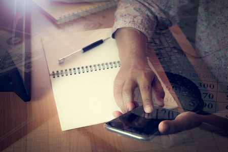 Hands of business woman touching smart phone screen. Double exposure finance accounting with money...