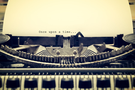 Words "Once upon a Time" written with old typewriter on white paper in vintage styleの写真素材