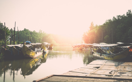 Many long tail boat at the pier in the morning under sunlightの写真素材