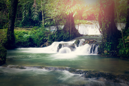 Sa Nang Manora cascade waterfall in tropical rain forest under sunlight, Phang Nga, Thailandの写真素材