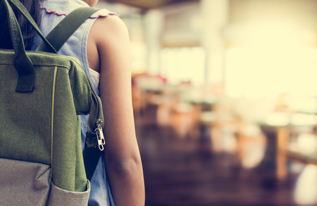 Girl with backpack entering to the classroom. Education concept.の写真素材