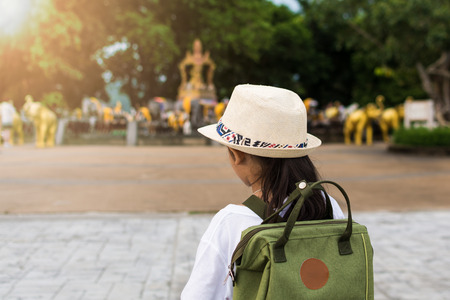 Girl with backpack viewing to a holy statue at promthep cape under sunlight.の写真素材