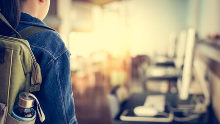 Girl with backpack entering to computer classroom, Education concept.の写真素材
