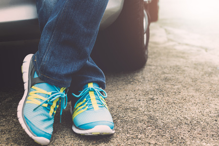 Traveller wearing jeans and sneakers standing beside the car. Travel concept.の写真素材