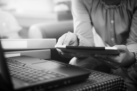 Businesswoman in casual dress holding tablet with online. while making orders via the Internet. Business And Financial Concept. Black and white picture.の写真素材
