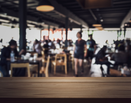 Emty wooden bar table with blurred people in the restaurant, For product display.の写真素材