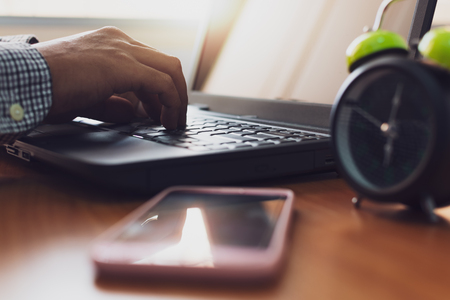 Hands of businessman typing with laptop on working desk in office, Business and technology concept.の写真素材