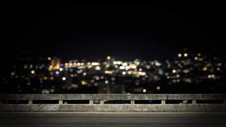 View from empty concrete bridge above the town at night with colorful bokeh.の写真素材