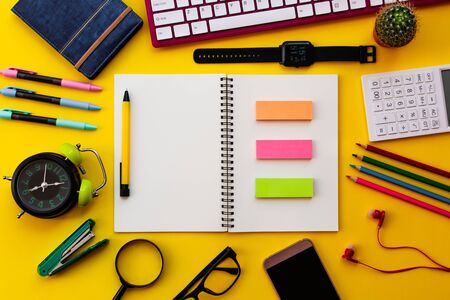 Blank white notepad with office and personal accessories isolated on yellow background, Business...