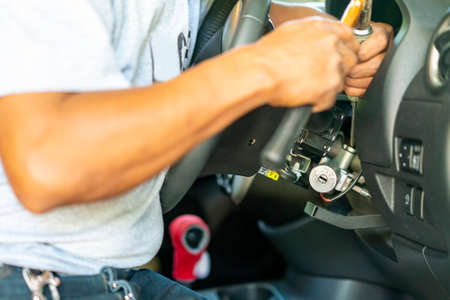 technician use screwdrivers and hammer during repair key or switch engine start of sedan car