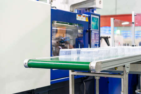 Many row of clear plastic cup or box after made by plastic injection mold machine on automatic...