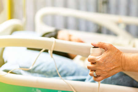 close up hand and button patient emergency calling for rescue nurse or doctor when have fever state in wardの写真素材