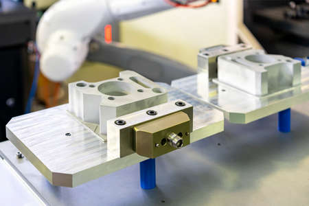Product workpiece set on fast or quick flexible holder clamp wait on work table for lift by robot...