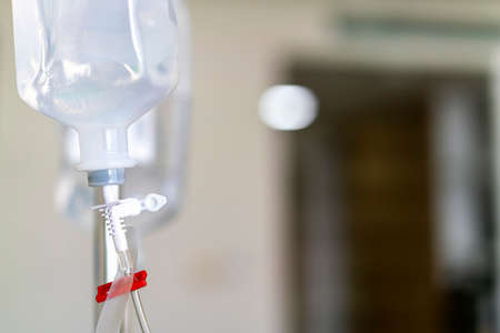 Sodium chloride or saline solution fluid iv irrigation transparent drip bag and tubing at room in hospitalの写真素材