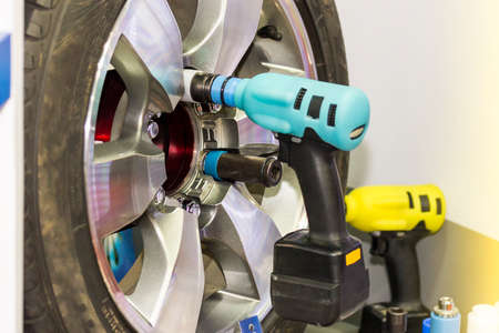 Close up electric wrench tool for assembly or un install car wheel at garage or workshopの写真素材