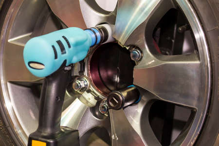 Close up electric wrench tool for assembly or un install car wheel at garage or workshop