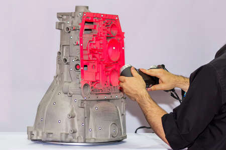 engineer or operator who emits pink light laser from a portable 3d scan (high accuracy equipment) to...