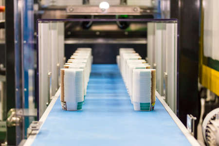 Many row of paper cup on automatic conveyor belt during manufacturing process in factory
