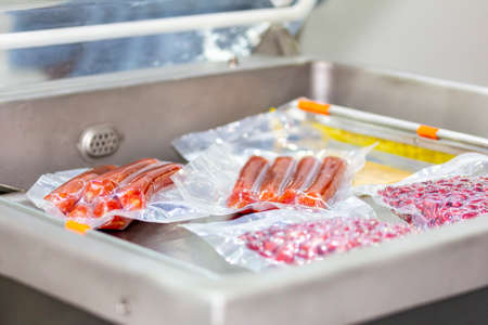 close up food or meat sausage after packing in envelope plastic on automatic vacuum packing machine