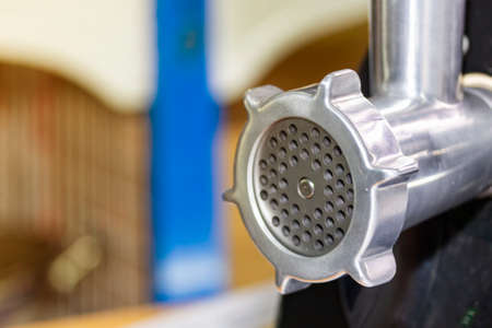 close up metal discharge head of meat grinder or mince machine for home or industrial